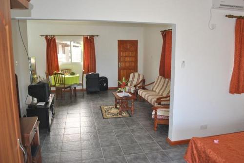 a living room with a couch and a table at Rowsvilla Guest House in Beau Vallon