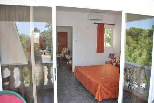 two pictures of a bedroom with a bed in a room at Rowsvilla Guest House in Beau Vallon