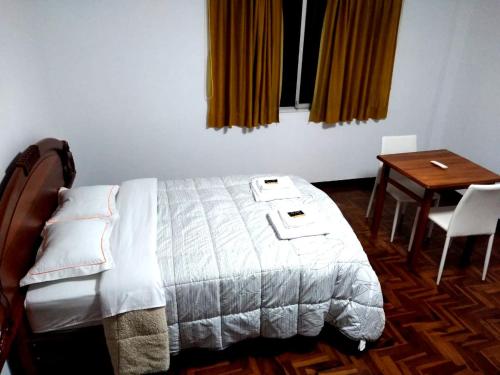 - une chambre avec un lit, un bureau et une table dans l'établissement Santa Victoria House, à Chiclayo