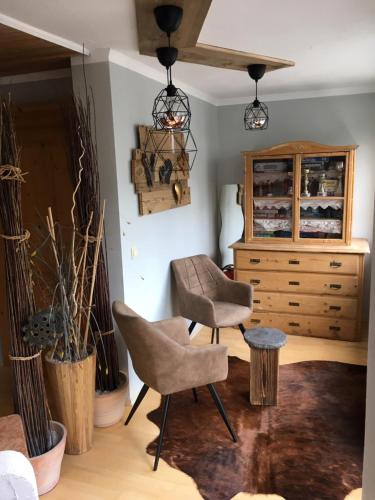 a living room with two chairs and a dresser at Haus Eder Steiner in Saalbach Hinterglemm