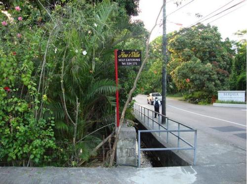 a sign on the side of a bridge on a road at Rowsvilla Guest House in Beau Vallon