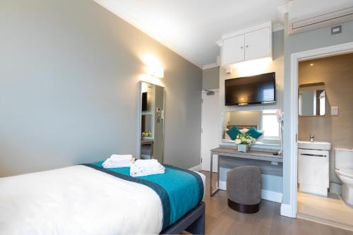 ein Hotelzimmer mit einem Bett und einem Bad in der Unterkunft SW1 Apartments in London