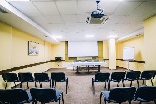 a conference room with chairs and a white screen at Optima Vinnytsia in Vinnytsya