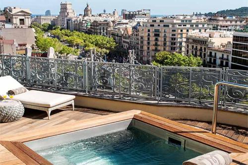 un balcone con vasca idromassaggio in cima a un edificio di Majestic Hotel & Spa Barcelona GL a Barcellona