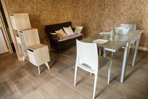 comedor con mesa, sillas y sofá en Étape de la Roulotte en Conty