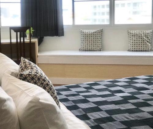 a bedroom with a couch with pillows and a window seat at Chill Chill at Nimman in Chiang Mai