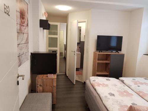 a small room with a bed and a flat screen tv at Historisch übernachten Brinkerplatz 3 in Essen