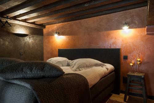 1 dormitorio con 1 cama grande con almohadas blancas en Apartments Breydelhof, en Brujas