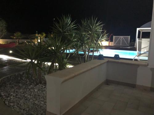 a view of a pool at night with palm trees at GIGLIO DI MARE Residence in Sellia Marina