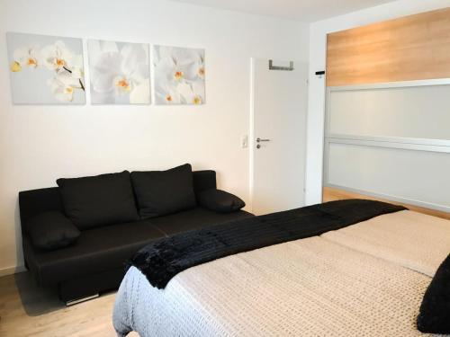 a living room with a couch and a bed at Schöne, neue Ferienwohnung am Rhein und mit Balkon in Bingen am Rhein