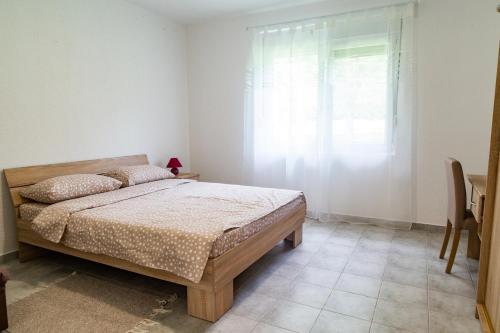 a bedroom with a bed and a window at Bogoljubova vinska koliba in Vrdnik