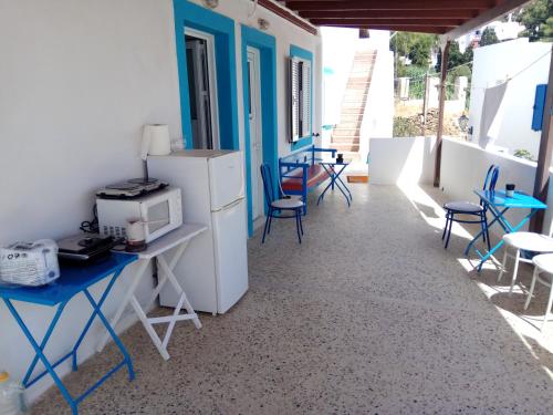 a room with tables and chairs and a refrigerator at Grandma Vasiliki Rooms To Let in Ios Chora