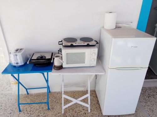 イオス島 チョーラにあるGrandma Vasiliki Rooms To Letの小さなテーブル(電子レンジ、冷蔵庫付)