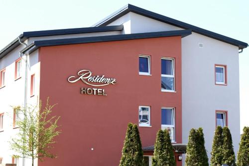 ein rot-weißes Gebäude mit einem Hotelschild darauf in der Unterkunft Hotel Residenz Babenhausen - Superior in Babenhausen