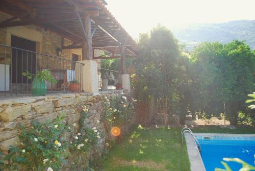 a stone wall next to a house with a swimming pool at Casa de Mendiz in Vale de Mendiz