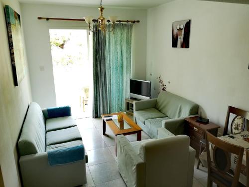 uma sala de estar com dois sofás e uma televisão em Faneromeni Court em Pafos