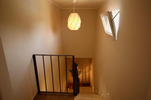 a staircase with a pendant light and a window at Katana suites beach in Agnone Bagni