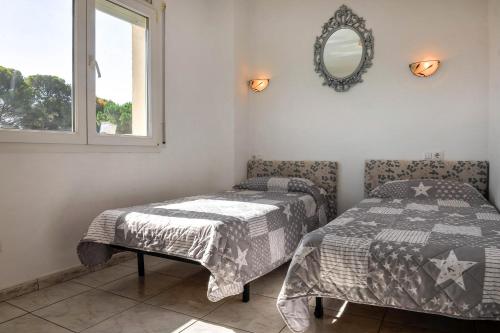 レスカラにあるMagdalenaのベッドルーム1室(ベッド2台、鏡、窓付)
