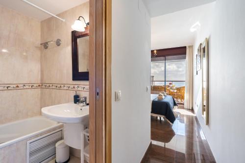 Sur Suites Buena Vista في فوينخيرولا: حمام مع حوض ومرحاض وحوض استحمام