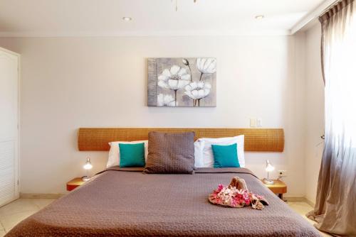 Oceanfront Deluxe Apartment Blue Marlin at Den Laman في كراليندايك: غرفة نوم بسرير مع صورة على الحائط