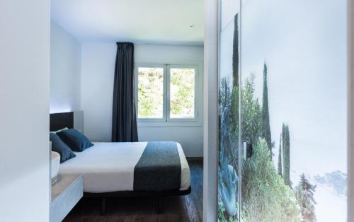 1 dormitorio con cama y ventana grande en Hostal Ribas en Lloret de Mar