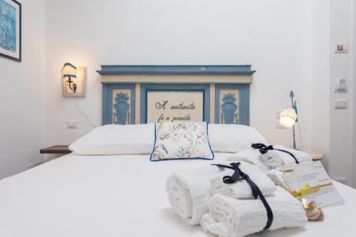 Una cama blanca con dos animales de peluche. en Addimora Boutique Suites en Palermo