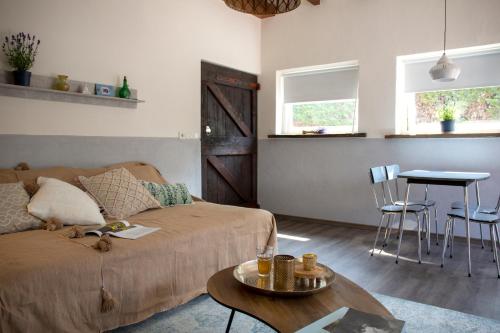 ein Wohnzimmer mit einem Sofa und einem Tisch in der Unterkunft Lavender Lodge in Achthuizen