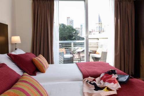 a bedroom with a bed and a large window at Argenta Suites Belgrano in Buenos Aires
