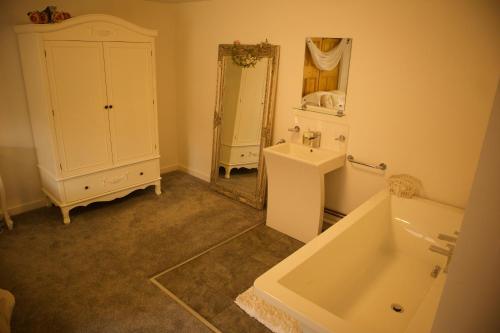 a bathroom with a sink and a tub and a mirror at Magna in Shilton