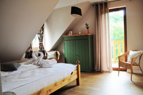 sypialnia z łóżkiem z zieloną szafką i oknem w obiekcie Apartamenty Homole Apartament D5 w mieście Szczawnica