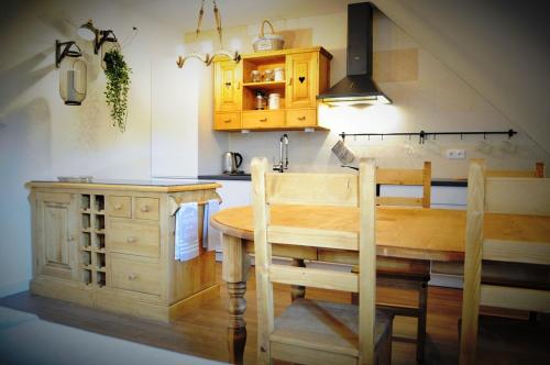 a kitchen with a wooden table and a sink at Apartamenty Homole Apartament D5 in Szczawnica