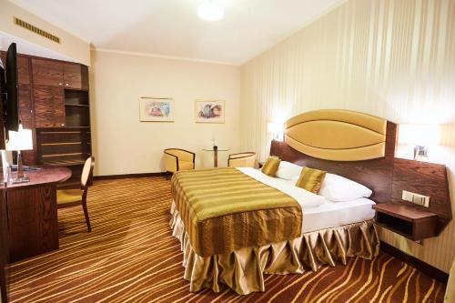 a hotel room with a bed and a desk at Casino&Hotel Admiral Alžbětín in Železná Ruda