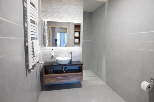 ein Bad mit einem Waschbecken und einem Spiegel in der Unterkunft Noclegi Restauracja Piwnica Rycerska in Kęty
