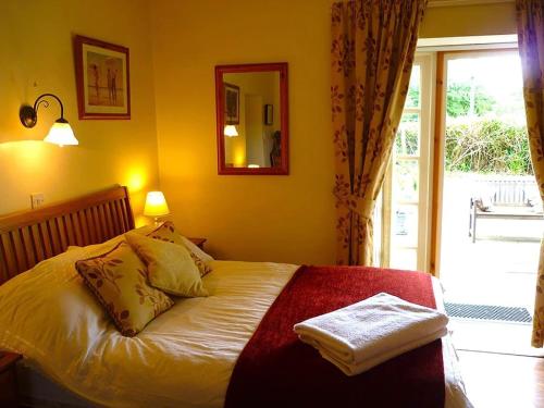 Whitecroft的住宿－The Miners Cottage，一间卧室设有一张黄色墙壁和窗户的床