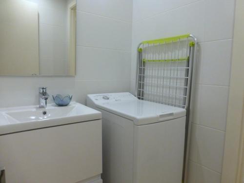 a white bathroom with a sink and a mirror at Rentalmar Delfos Playa in Salou