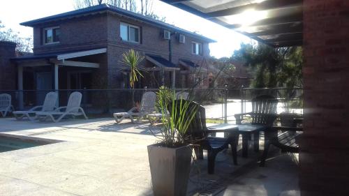a patio with a table and chairs and a house at Descanso del Molino in Luján