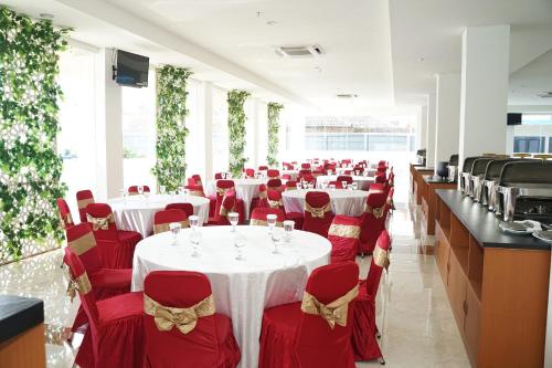eine Reihe von Tischen mit roten Stühlen und weißen Tischdecken in der Unterkunft HOTEL NALENDRA PLAZA SUBANG in Subang