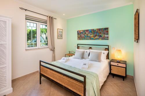 a bedroom with a bed and a window at Epic Falésia Apartment by The Portuguese Butler in Olhos de Água