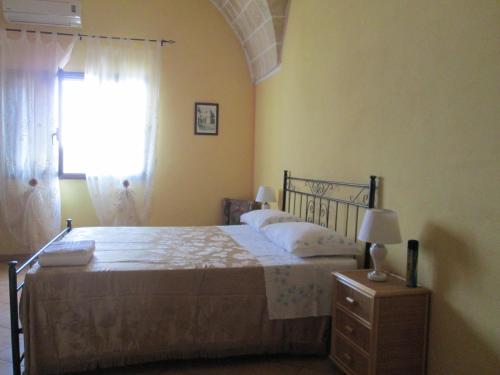 a bedroom with a large bed and a window at B&B Largo Fontana in Leverano