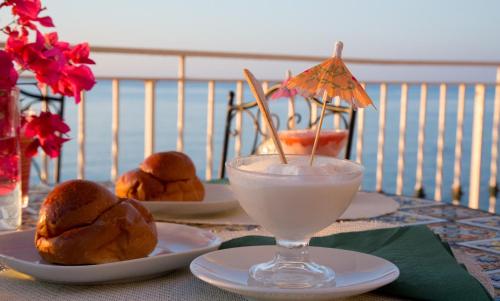 a table with two plates of food and a drink at Appartamento in Villa Agnese in Acitrezza