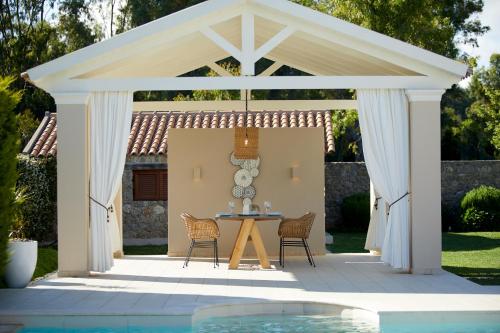 a pavilion with a table and chairs on a patio at S & O Villas Corfu in Dassia