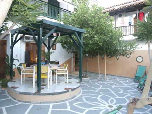 patio ze stołem i krzesłami w budynku w obiekcie Mitsa w mieście Skiatos