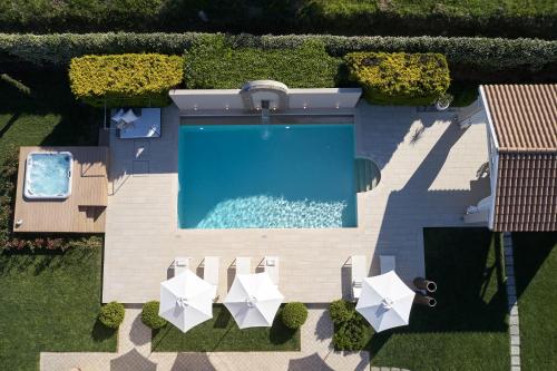 an overhead view of a swimming pool with white umbrellas at S & O Villas Corfu in Dassia