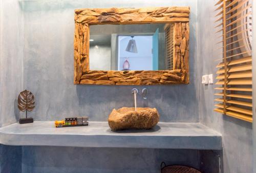 a bathroom with a mirror and a rock on a sink at Margarita Hotel in Firostefani