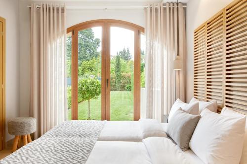 a bedroom with a white bed and a large window at S & O Villas Corfu in Dassia
