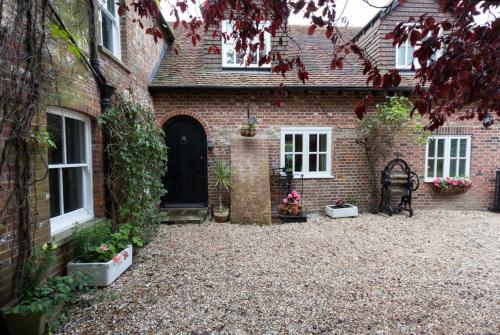 a brick house with a courtyard in front of it at Hanger Down House Bed and Breakfast in Arundel