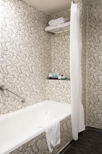 a white bench in a bathroom with wallpaper at Crowne Plaza Toluca - Lancaster by IHG in Toluca