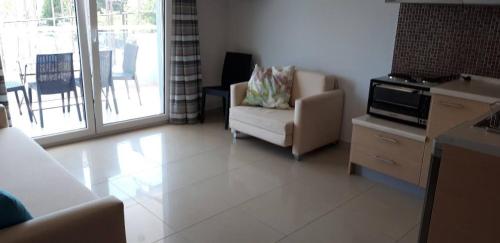 a living room with a couch and a chair at TETYK Keramoti Hotel Apartments in Keramotí