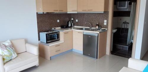 a small kitchen with a sink and a microwave at TETYK Keramoti Hotel Apartments in Keramotí