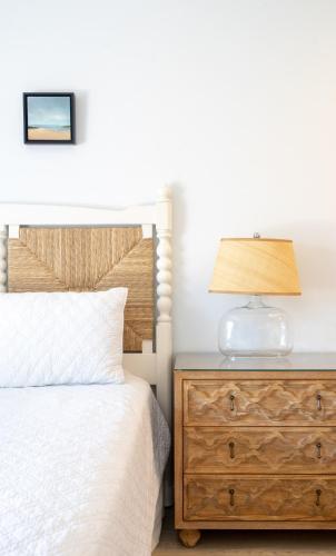 a bedroom with a bed and a lamp on a dresser at Windward Shores in Amagansett
